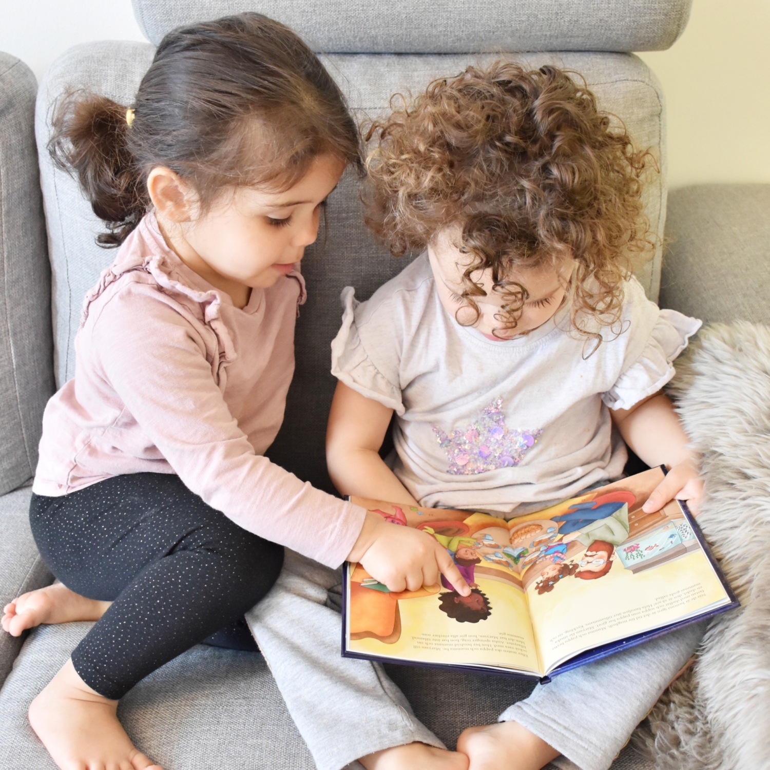 Två barn läser en barnbok om ramadan.