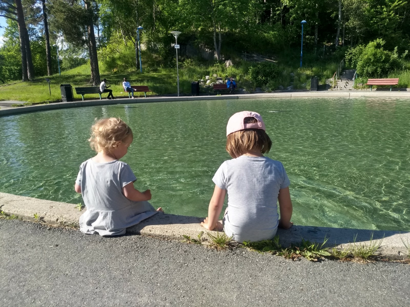 Två barn badar fötterna i plaskdamm