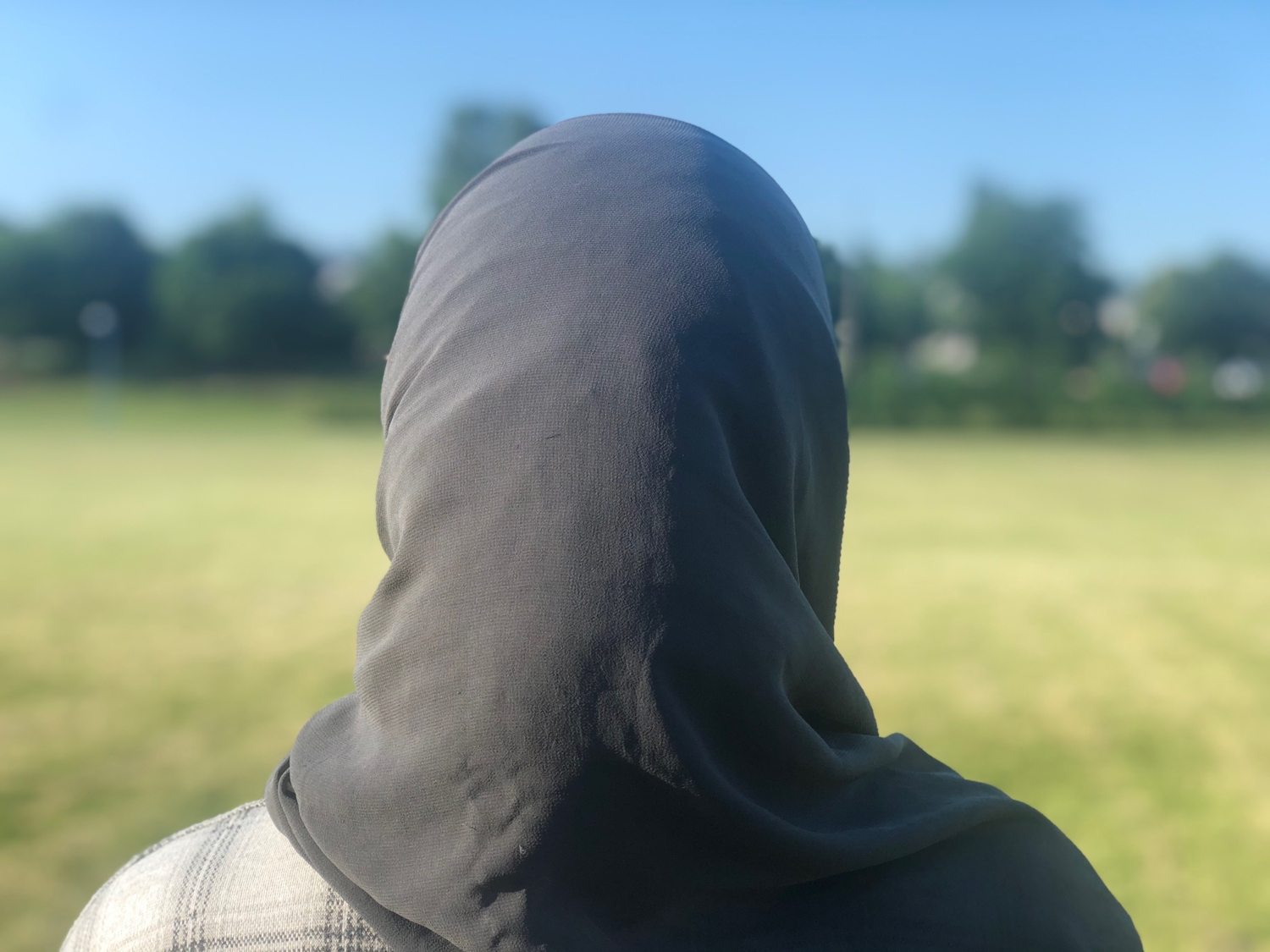 Tjej i hijab fotograferad bakifrån.