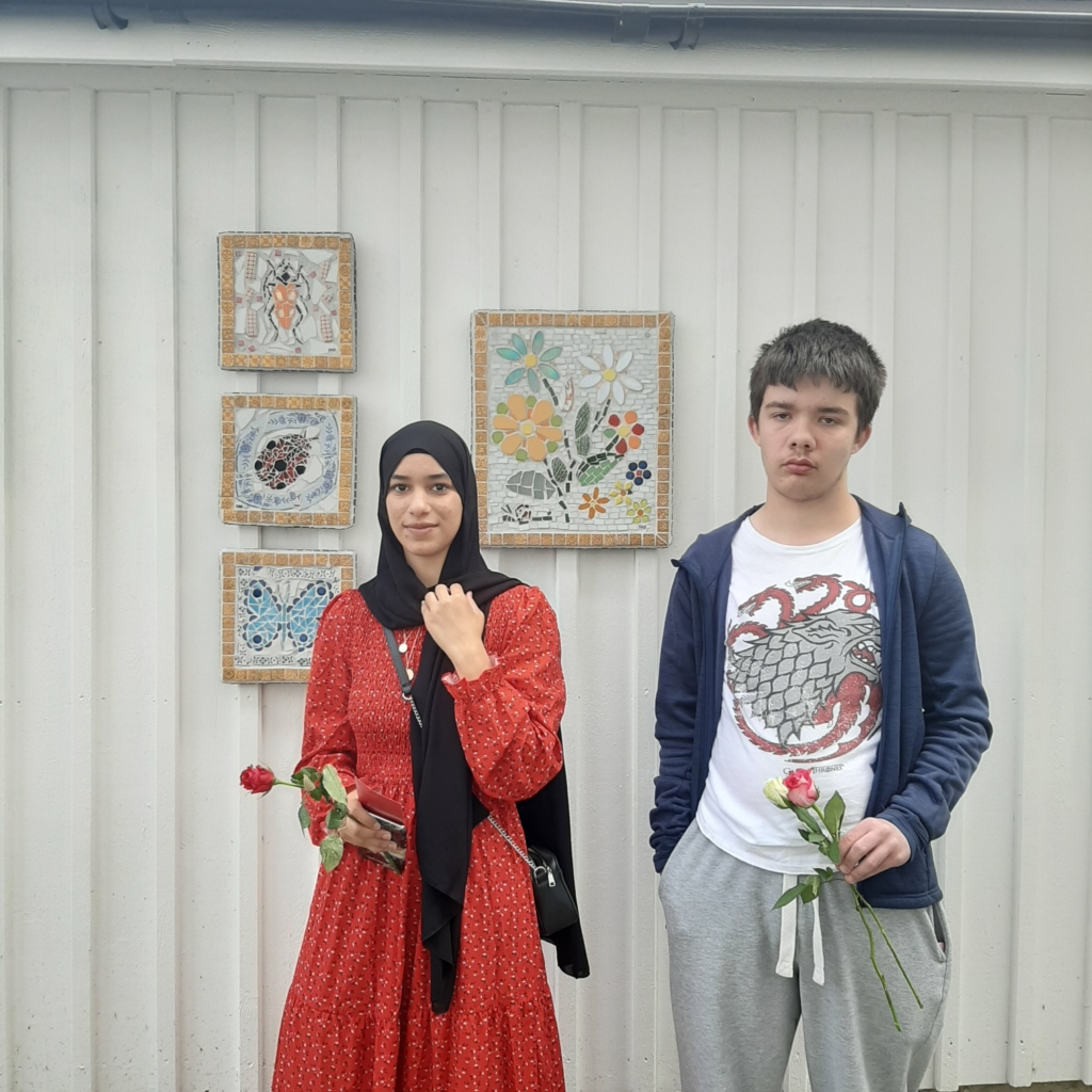två ungdomar framför mosaik